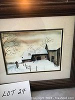 Photo of the framed Trisha Romance print showing a winter barn scene with snow and a person, in a wooden frame with matting.