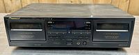 Front view of the Pioneer stereo double cassette deck CT-W616DR showing dual cassette compartments, control buttons, and digital display.