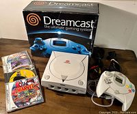 Full setup: console, boxed packaging, controller, cables and four game cases