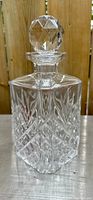 Front view of clear lead crystal decanter with geometric diamond cut pattern and original stopper, showing overall condition and design details.