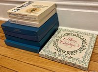 Stacked view of original boxes containing vintage Goebel and Royal Doulton Christmas plates, showing box variety and condition.