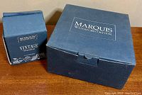Two blue boxes labeled Marquis Waterford Crystal and Vintage Tasting Collection containing the shot glasses and bowl set.