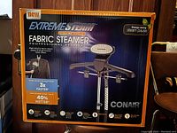 Front and side views of the Conair Extreme Steam fabric steamer original packaging box showing branding, product features, and images.