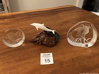 Group photo of all items on a wooden table showing the crystal panda, crystal bird, and white dolphin on wood burl.