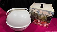 Photo of white round bowl with handle storage container alongside original Pic Boll box