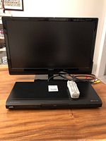 Insignia 24-inch TV next to JVC DVD/CD player and remote, showing overall condition and included accessories.