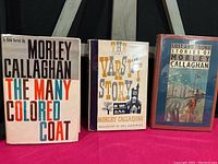 Three hardcover first edition books by Morley Callaghan shown side by side on stand.