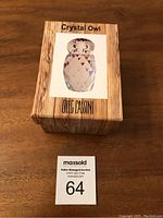 Oleg Cassini branded box with wood-grain print and labeled 'Crystal Owl'