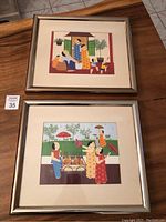 Two framed John Lim prints depicting traditional scenes. Frames show wear and scratches.
