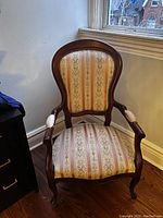 Front view of the Queen Anne chair showing upholstered back and seat with wood frame