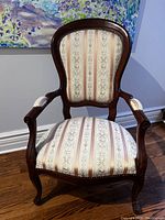 Front view of the Queen Anne style chair showing upholstered seat and backrest with wooden frame and curved arms.