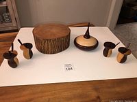 Full lot setup showing mango wood pedestal in center, lidded birdseye maple and padauk trinket holder on right, four small wood condiment holders with spoons arranged around pedestal.