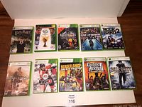 Full view of all 10 Xbox 360 game cases arranged in two rows on a wooden surface, clearly showing front cover artwork and titles.