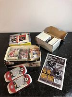 Various boxes and bundles of hockey cards, NHL All-Stars Medallion Set, and Hockey Pool Almanac on tabletop.