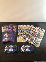 Photo of hockey player collectible cards spread in rows with two blue metal tins labeled NHL All-Stars 2002 Stamp & Medallion Set Red Kelly