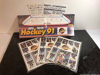 View of Super Poster Hockey 91 poster folded, four hockey inserts, and package box showing set name