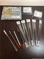 Top-down view of all items including pastel box, brushes in plastic sleeves, and two small packs with white items.