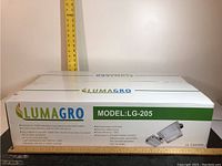 Photo of boxed Lumagro LG-205 indoor grow light with branding and model information.