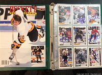 Image of Beckett Hockey Monthly binder cover and signed cards in protective sheets.