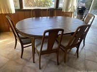 Full set including oval dining table and six matching chairs positioned around it