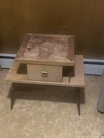 Blond wood midcentury side table with a single drawer and square metal pull, showing light wear on the surface.