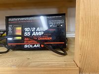 Close-up of front panel showing brand name Solar, output 10/2 AMP, 55 AMP starter, 12 volt dual range battery charger starter.