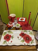Overview of entire lot showing ceramic platter, red container, utensil holder, napkins, and decorative items