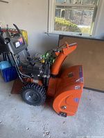 Profile view showing auger housing, chute, engine, and handles