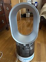 Full front view of Dyson humidifier showing its bladeless oval loop and transparent water tank detail.