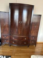 Front view of the entire Ethan Allen armoire set including main unit and two side cabinets, showing wood finish, hardware, and overall condition.