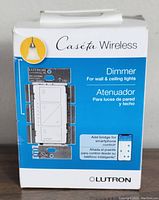 Front box with Caséta Wireless branding, product name and image of dimmer switch.