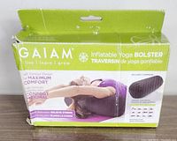 Front view of Gaiam Inflatable Yoga Bolster box showing product image, branding and key features like maximum comfort and stress relief.