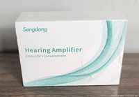 Photo of sealed Sengdong Hearing Amplifier retail box with branding and product type visible