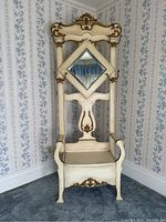 Front view of antique cream and gold French Provincial style hall tree bench with diamond beveled glass mirror and carved detailing.