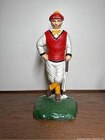 Front view of the cast iron golfer door stop showing full figure and green base.