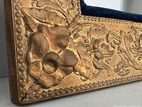 Close-up of corner detail showing floral gesso work and slight crack.