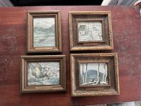 Four framed early prints of Canadian landscapes by Group of Seven members and affiliates arranged on table.