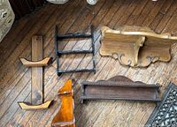 Overview of six assorted wooden wall shelves displayed on wooden floor showing variety in styles and colors