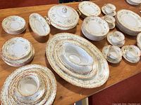 Overall set displayed showing multiple plates, cups, saucers, and serving dishes arranged