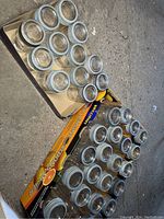 Top-down angled view of multiple clear glass canning jars with metal rims and lids arranged in cardboard trays.