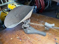 Full view of the entire cast iron scale with a scoop pan and a bird weight on the balance beam, showing overall condition.