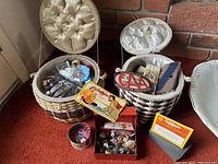 Wide shot of both sewing baskets open and filled with assorted sewing items including needles, buttons, thimbles, and pins.