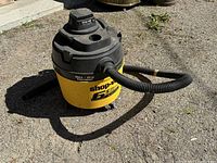 Shop-Vac wet and dry vacuum 6.5 gallon unit with attached hose on outdoor surface.