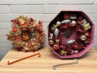 Both wreaths shown together; autumn wreath on stand, Christmas wreath in maroon box