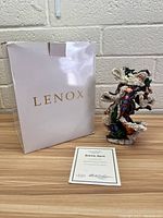 Photo showing Lenox white storage box, porcelain Santa figurine, and certificate on wood surface