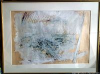 Framed abstract art with layered white and gray brush strokes over a beige background. Simple gold frame and white matting.