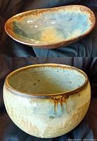 Photo showing both pottery pieces, the shallow oval dish on top and the round pot below, highlighting color and texture.