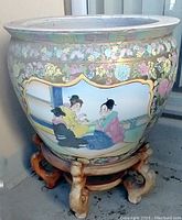 Large painted ceramic planter featuring Chinese-themed artwork of three women in traditional attire, set on a carved wooden stand