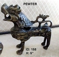 Photo of pewter dragon sculpture showing overall shape, details, and neck damage.