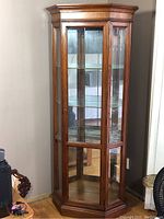Full view of front of Craftline wood and glass curio cabinet with three interior glass shelves.